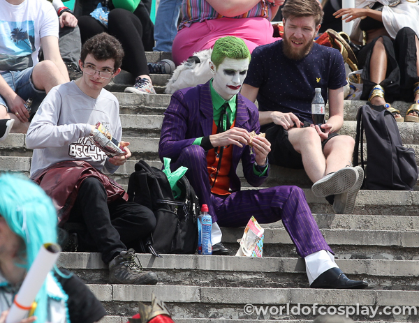 A brilliant Joker cosplayer with a friend (dressed normally) who can help him with his costume, and hold their bags when the Joker has his picture taken.